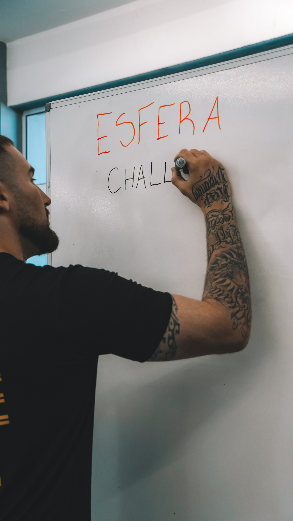 Coach Tony Ribeiro planejando treino personalizado no quadro da Esfera